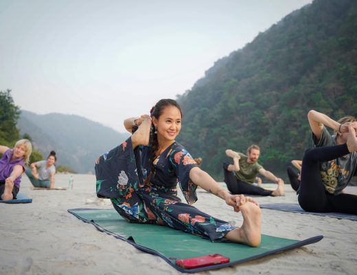Indonesian yoga instructor holding an outdoor class in a scenic area surrounded by lush green mountains