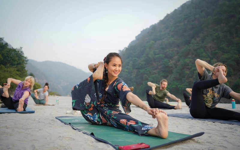 Indonesian yoga instructor holding an outdoor class in a scenic area surrounded by lush green mountains