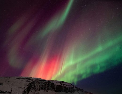 colorful northern lights over snow-covered mountains in Iceland