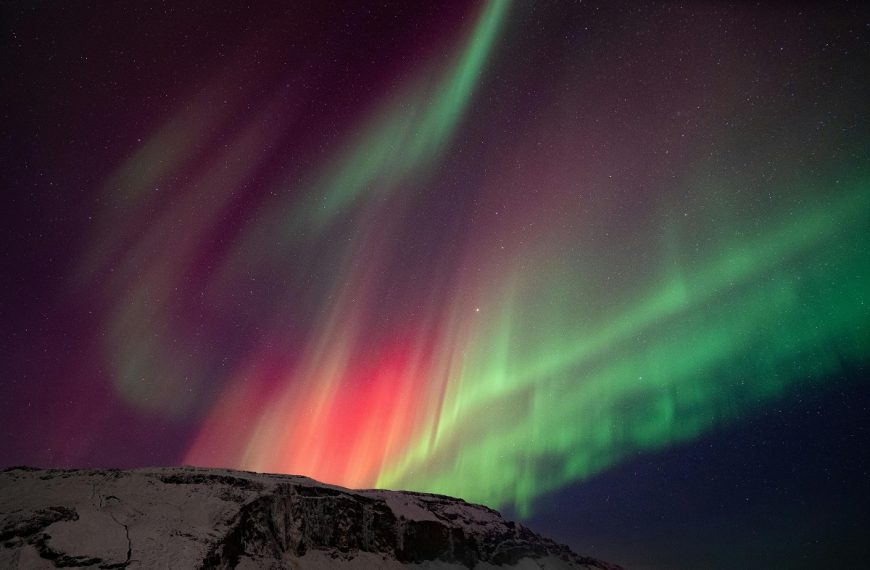colorful northern lights over snow-covered mountains in Iceland